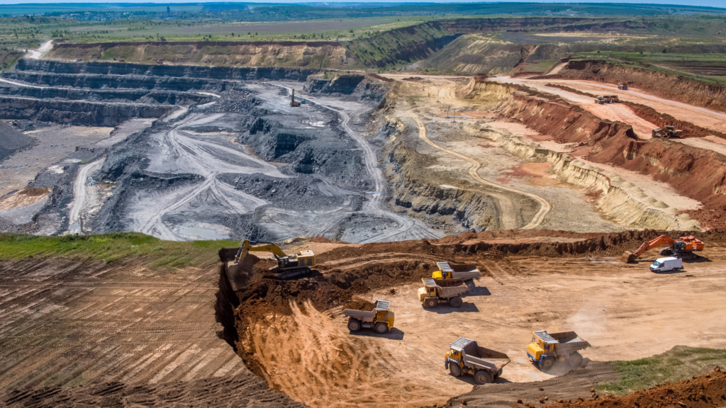 "Open-pit mining fleet of haul trucks and excavators operating across tiered benches — managed with SmartDSM™ mining fleet analytics